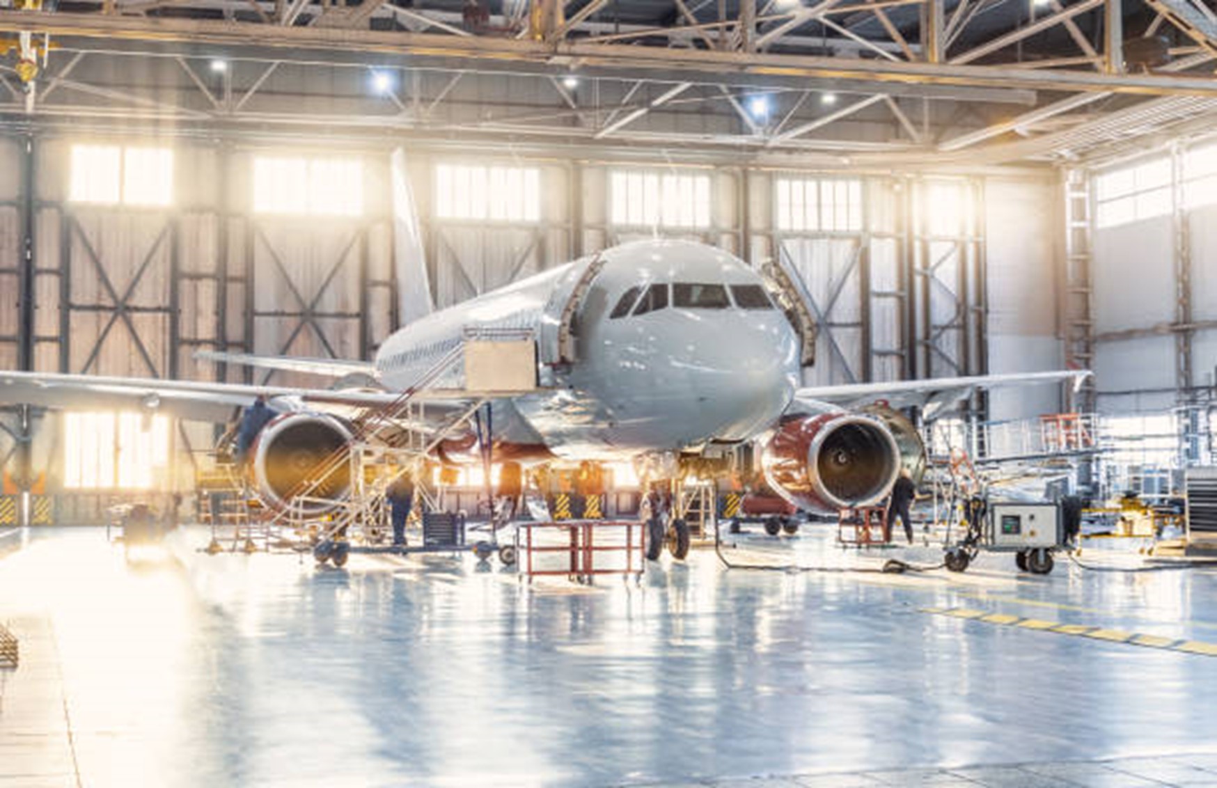 Featured image for What is ISO 9001: 2015. Image shows a top quality aircraft gleaming in an hangar as engineers work on it.